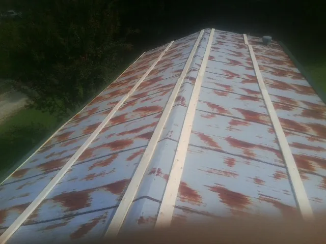 Rusted metal roof panels with new wood purlins before replacement — Storm Damage Roof Repair in Glen by Roofing Brothers